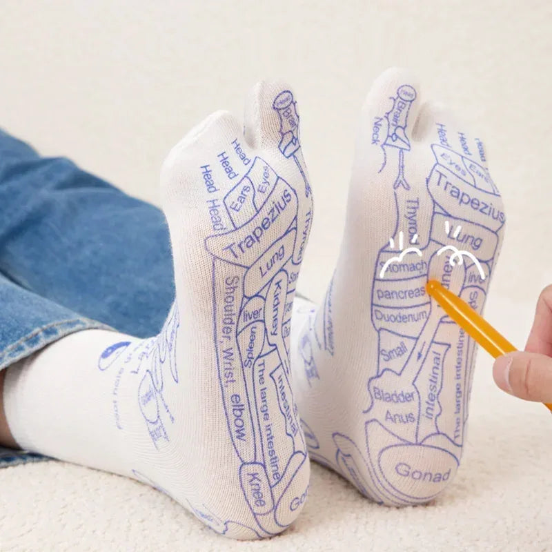 White socks with blue anatomical diagrams worn by a person, with a hand holding a pen pointing to the diagrams.
