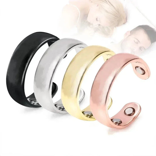 Four metallic rings in black, silver, gold, and rose gold on a white background